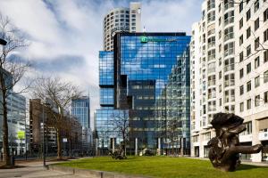 a sculpture in a park in front of tall buildings at Holiday Inn Express Rotterdam - Central Station, an IHG Hotel in Rotterdam
