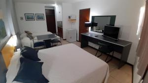 a hotel room with a bed, desk and a television at Apart Hotel Alvear in Rosario