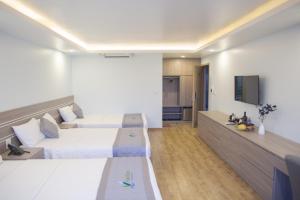 ein Hotelzimmer mit 2 Betten und einem Flachbild-TV in der Unterkunft Bamboo Hotel in Thanh Hóa