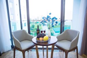 einen Tisch mit einer Schale Obst und Weinflaschen in der Unterkunft Bamboo Hotel in Thanh Hóa