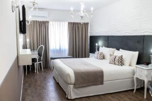 a hotel room with a large bed and a desk at Ker San Telmo Hotel in Buenos Aires