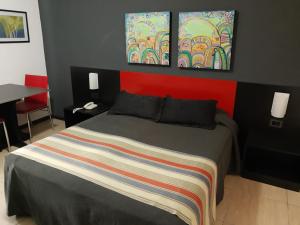 a bedroom with a bed and a desk at Apart Hotel Alvear in Rosario