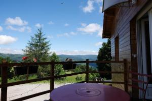 una mesa en un balcón con vistas a las montañas en Maison avec piscine couverte Pilat Ardèche, en Saint-Sauveur-en-Rue