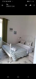 um quarto com uma cama branca e uma janela em Domus Linda B&B em Ischia