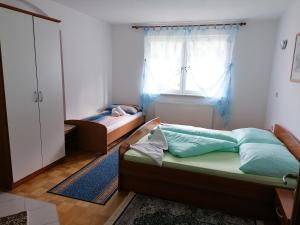 1 dormitorio con 2 camas y ventana en Rezidenca Ervin, en Jesenice