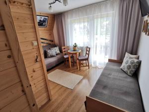 un piccolo soggiorno con tavolo e porta di Ceperka a Zakopane