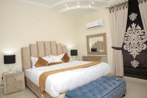 1 dormitorio con 1 cama grande con reposapiés azul en Premier Inn Grand Gulberg Lahore en Lahore