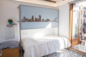 una camera da letto bianca con un grande quadro sul muro di Finca Reloj a Valencia