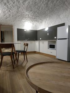 a kitchen with a table and a white refrigerator at Holly Place in Coober Pedy