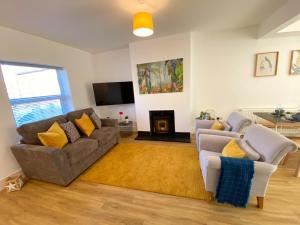 a living room with a couch and a fireplace at Stunning New House - Great Location - Garden - Parking - Fast WiFi - Smart TV - Beautiful 2 Bedroom House sleeps up to 6! Only 5 min drive to Sandbanks beach! in Parkstone