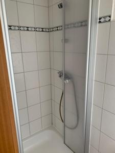 a shower with a glass door in a bathroom at Café Freudenstein in Lohfelden