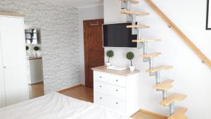ein Schlafzimmer mit einer weißen Kommode und einem TV an der Wand in der Unterkunft Spreewald-Ferienwohnung Reschke in Radensdorf