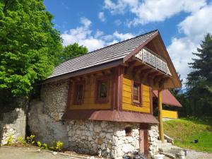 a small house with a wooden roof at Domek w skale in Kroczyce