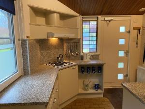 a kitchen with a stove and a counter top at Robbenoort 45 in Lauwersoog