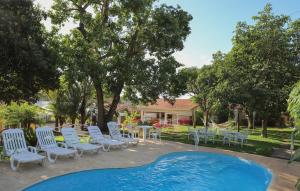 a group of chairs and a table and a pool at Alambari Village in Alambari