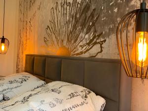 ein Bett mit zwei Kissen und einem Gemälde an der Wand in der Unterkunft Zeit in Hambach in Neustadt an der Weinstraße