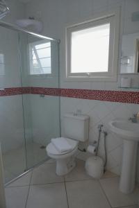 a bathroom with a toilet and a sink and a window at Alambari Village in Alambari