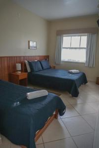 a bedroom with two beds and a window at Alambari Village in Alambari