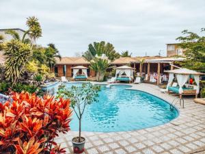 una piscina in un cortile con sedie e alberi di Tuzco Lodge a Puerto López