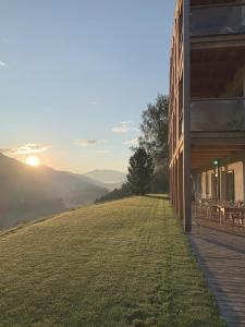 un edificio con un campo de césped junto a un edificio en Gailerhof Hotel B&B Superior en Monguelfo