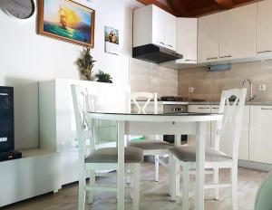 cocina con mesa blanca y sillas en Kuća za odmor Dobrila en Jelsa