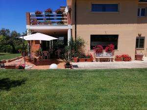 オルトーナにあるLa Collina del Riccioの傘と芝生のある家