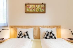 1 dormitorio con 2 camas y una foto en la pared en Spitalerhof, en Verano