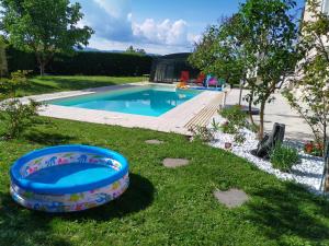 a swimming pool in the grass next to a yard at Chalet de TARA - Grand appartement esprit chalet - piscine chauffée - Genève in Collonges-sous-Salève