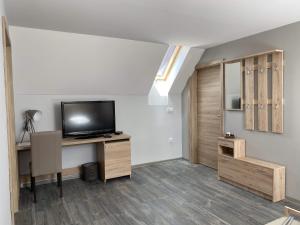salon z telewizorem i biurkiem z telewizorem w obiekcie Kis Szieszta panzió w mieście Balatonboglár