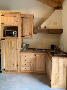 una cocina con armarios de madera y fregadero en LA DRIT, en Paesana