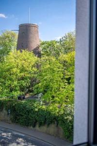 une tour en briques assise au sommet d'une colline avec des arbres dans l'établissement JaHotel, à Geldern
