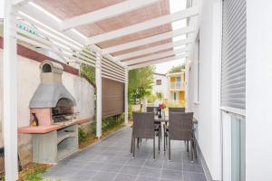 a patio with a pizza oven and a table and chairs at ZILIP Apartments in Vir