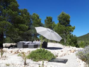 Biały parasol siedzący w piasku obok kanapy w obiekcie Cortijo Blanco w mieście Vélez Blanco
