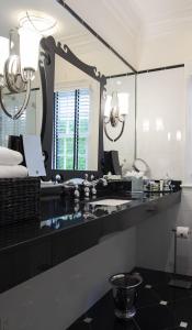 a bathroom with a sink and a large mirror at The Gardens Hotel in Key West