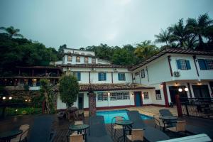 una casa con piscina, mesas y sillas en Hotel Solar Das Lajes, en Ouro Preto