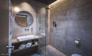 een badkamer met een wastafel en een spiegel bij Gailerhof Hotel B&B Superior in Monguelfo