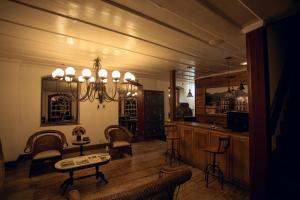 uma sala de estar com um lustre e uma mesa e cadeiras em Hotel Solar Das Lajes em Ouro Preto