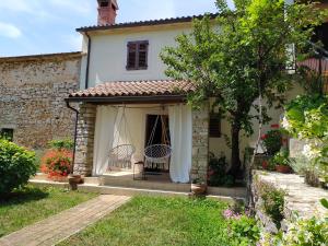 ganek domu z dwoma krzesłami w obiekcie Apartment PARENZANA, little row HOUSE with big green yard in central Istria w mieście Rakotule