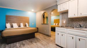 a bedroom with a bed and a kitchen with a sink at Executive inn Bacliff in Bacliff