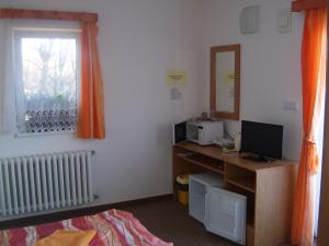 Zimmer mit einem Schreibtisch, einem Computer und einem Fenster in der Unterkunft Penzion Zlatá rybka in Podhájska