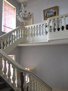 una escalera en una casa con una lámpara de araña en Château de Couin, en Couin