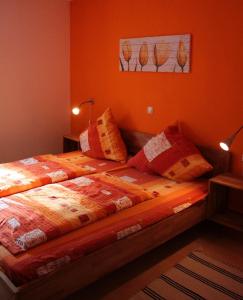 sypialnia z 2 łóżkami i pomarańczowymi ścianami w obiekcie Ferienanlage Karolinenhof w mieście Haundorf