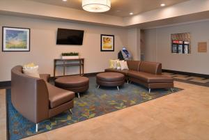 a waiting room with couches and chairs and a television at Candlewood Suites - Austin Airport, an IHG Hotel in Austin