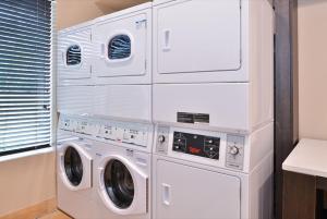 a pile of white washers and dryers in a room at Candlewood Suites - Austin Airport, an IHG Hotel in Austin