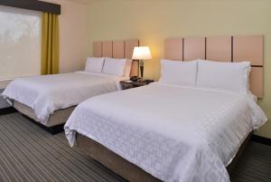a hotel room with two beds with white sheets at Candlewood Suites - Austin Airport, an IHG Hotel in Austin