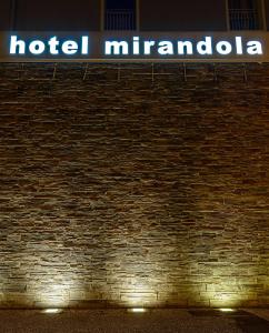 Una señal de hotel Miranda en un lado de una pared de ladrillo en Hotel Mirandola, en Mirandola