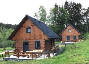 a log cabin with picnic tables in front of it at Roubenky Bublava in Bublava