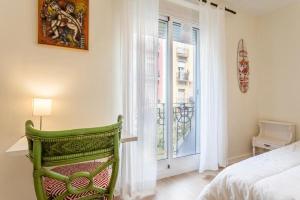 a bedroom with a green chair in front of a window at Apartamento Ruzafa Centro II in Valencia