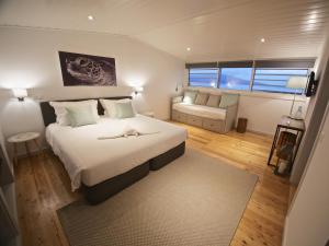 Manta Ray Lodge في أورتا: غرفة نوم بسرير كبير وأريكة