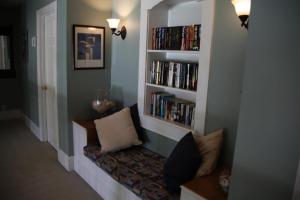 a living room with a book shelf filled with books at The Inn on Bath Creek in Bath
